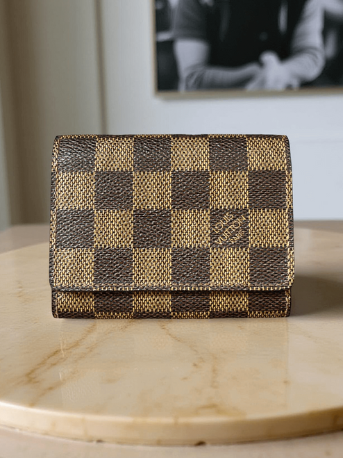 Louis Vuitton Damier Ebene Card Holder front view in brown checkered canvas with LV logo at bottom right