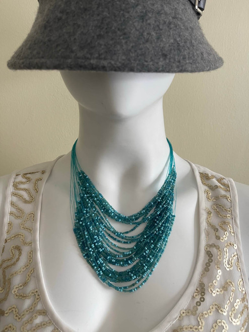 Teal Beaded Multiple Layered Necklace worn on mannequin with multiple layers to teal beads draped on the neck