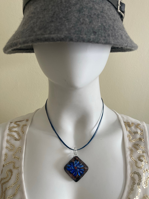 Square Glass Flower Pendant Necklace on mannequin with vibrant blue & light blue flower, black gold glitter background