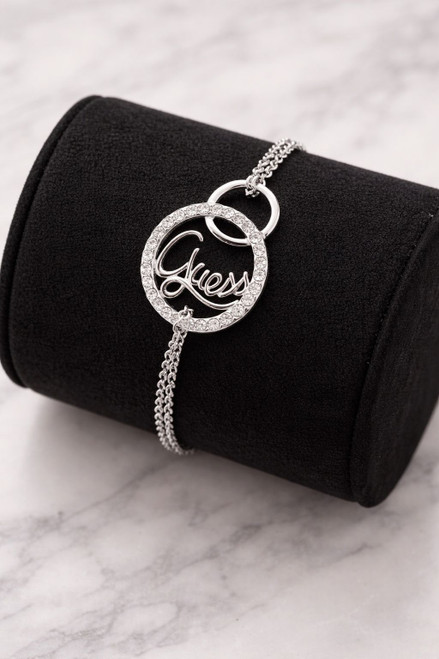 Guess Silver Diamanté Circle Logo Chain Bracelet on black holder showing diamanté circle frame & Guess script detail