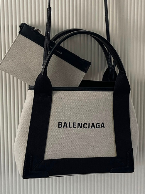 Balenciaga Cabas XS Ivory Canvas Tote & Pouch hanging with black leather trim, dual top handles & branded zip pouch