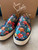 Christian Louboutin Skull Print Slip-On Spike Sneakers front facing in red, blue, green & orange skull print & white soles