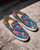 Christian Louboutin Skull Print Slip-On Spike Sneakers front view facing right showing white soles & spike details