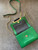 Diane Von Furstenberg Green Crossbody Mini Bag top down with open black lined monogram flap & gold magnetic close