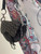 Christian Dior Black Monogram Saddle Bag close up hanging off a mannequins arm in grey, & silver C & D hardware