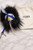 Fendi Monster Bag Charm front top view on white surface with blue & yellow face, black & white hair with Fendi dust bag