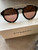 Givenchy Brown Tinted Aviator sunglasses front showing square gold accents on the frames displayed on white Givenchy box