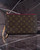 Louis Vuitton Neverfull Monogram Pochette front view with LV monogram canvas, pink zip trim & leather wrist strap