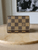 Louis Vuitton Damier Ebene Card Holder front view in brown checkered canvas with LV logo at bottom right