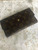 Louis Vuitton Monogram Trifold Wallet angled view of brown monogram canvas & full flap with tarnished press-stud closure
