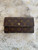 Louis Vuitton Monogram Trifold Wallet front view of brown monogram canvas & full flap with tarnished press-stud close