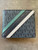 Michael Kors Embossed Cooper Logo Wallet top-down of compact design with teal, navy & white diagonal accents