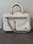 Michael Kors White Elliot Messenger Bag front flat lay with smooth top handles, silver hardware & 3 front zip compartments