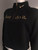 Nike Cropped Black Fleece Sweater angled front in cropped cut, gold half zip, long sleeves  & chest slogan