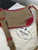 Prada Canapa Canvas Crossbody Bag front view on white Prada dust bag in brown canvas, red trim & embroidered Prada logo
