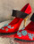 Prada Red Satin Mary Jane Heels close-up of toes with blue beaded floral detail on red satin