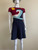 Red Valentino Navy Knit Mini Dress front showing color-block design with sun & wave motif in blues & white & short-sleeves