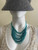 Teal Beaded Multiple Layered Necklace worn on mannequin with multiple layers to teal beads draped on the neck