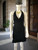 Black Halter Neck Mini Dress front view on mannequin showing plunge neckline, cinched waist, & angled ruffle hem