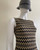 Gold Chevron Bodycon Mini Dress angled view highlighting sleeveless cut and metallic zigzag texture