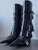 Versace Black Leather Pin-Point Buckle Boots angled side view of 5 silver V buckles, sleek pointed toes