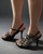 Miss Black Floral Rhinestone Heel Sandals side profile on model showing slim heel, ankle strap & floral rhinestones