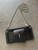 Black Mini Crossbody Bag closer front flay lay with smooth finish, stitched edges, silver zip closure & ball chain strap