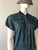 Canifa Teal Short Sleeve Zip Blouse – angled front view showing ring pull zip neckline & black collar detail