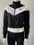 Nike Black Cropped Full Zip Track Jacket angled front with high collar zipped up & long sleeves with ribbed cuffs.