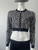 Michael Kors Black Leopard Print Cropped Knit Zip Jacket angled front showing cropped fit on mannequin - zip fully closed