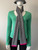 Michael Kors Grey MK Monogram Knit Scarf worn around mannequin neck in light grey base with all over darker grey MK logos