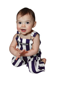 A baby wearing purple & white infant game bib overalls. A baby wearing purple & white infant game bib overalls.