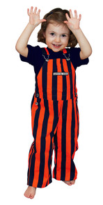 A little girl wearing striped navy blue & orange toddler game bib overalls