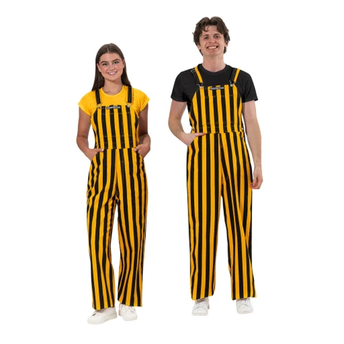 Front view of a smiling man and woman wearing matching black and yellow vertically striped Game Bibs overalls.