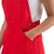 Close-up detail of the front chest on solid red Game Bibs overalls, displaying the stitched center pocket, adjustable shoulder straps, and the Game Bibs logo tag.