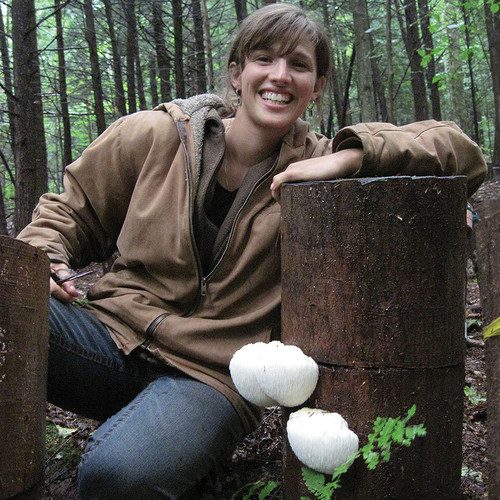 A woman next to a fruiting lion's mane totem.
