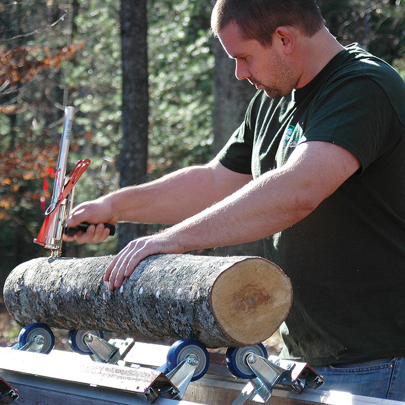 Man using a Okuda Hand Inoculator to inoculate a log and seal spawn with a foam cap in one easy movement