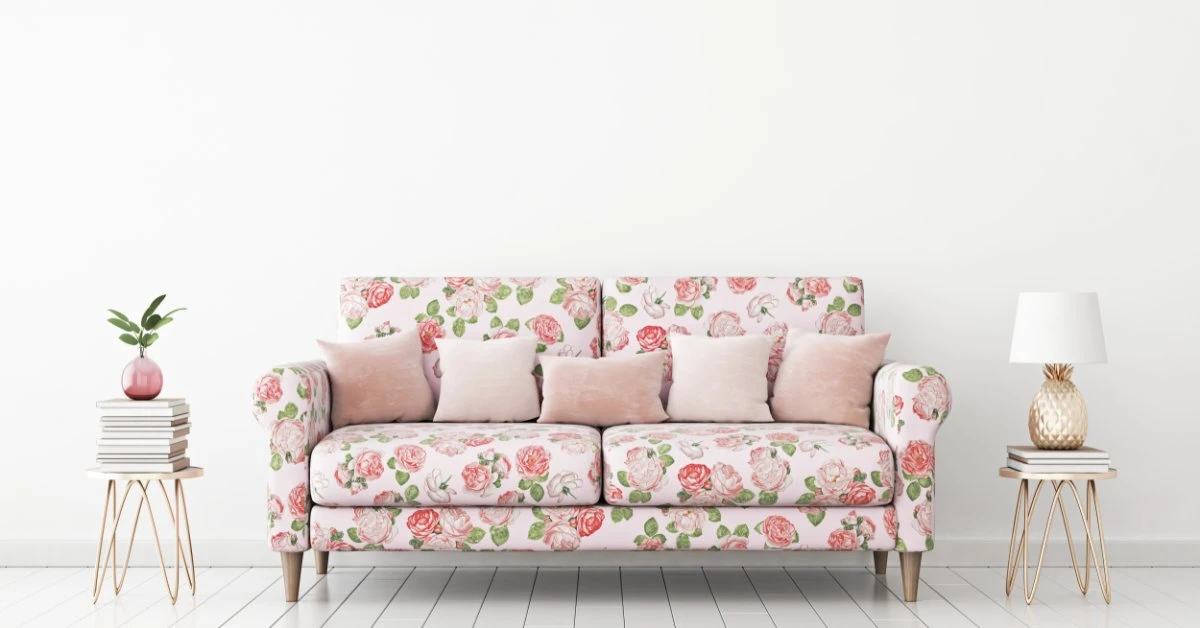 A tropical living room has a rattan furniture set. The sofa and armchair are upholstered in a tropical floral print.