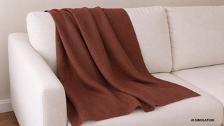 AI simulation of rust brown solid upholstery fabric draped over a cream sofa in a studio setting, showing realistic folds, texture, and fabric behavior. The image is a digital visualization created from an actual fabric photograph and is intended to demonstrate color, pattern, and general appearance.