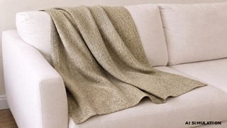 AI simulation of beige textured upholstery fabric draped across a white sofa, showcasing the fabric's woven texture, soft drape, and natural folds in a neutral residential interior. The image is a digital visualization created from an actual fabric photograph and is intended to demonstrate color, pattern, and general appearance.