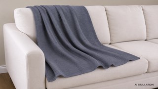 AI simulation of fabric draped over a cream upholstered sofa, featuring a slate blue textured woven fabric with realistic folds, natural drape, and a studio-style interior presentation. The image includes an AI SIMULATION label in the lower-right corner. The image is a digital visualization created from an actual fabric photograph and is intended to demonstrate color, pattern, and general appearance.