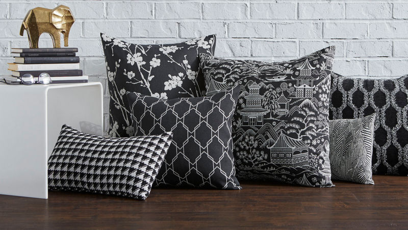 Black and white decorative pillows featuring Covington home decorating fabric in floral, geometric, scenic, houndstooth, and textured patterns