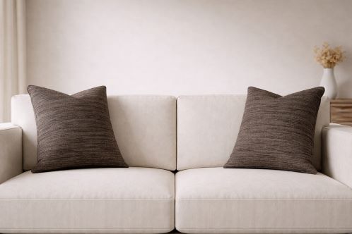 Neutral sofa with dark brown textured pillows representing Golding upholstery fabrics