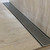 Modern Lauxes NeXT Generation NXT26 Silk Silver Aluminium Linear Shower Grate installed in a contemporary Australian bathroom floor.