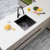 Aguzzo 440mm black stainless steel single bowl kitchen sink installed as a topmount on a light-colored countertop in an Australian home.