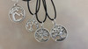 Round Live oak tree pendant on cotton cord shown with other silver trees to show scale and size differences