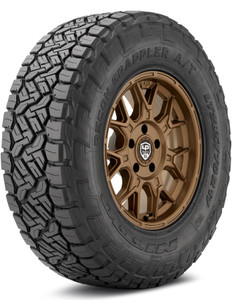 A large off road tire made by Nitto, installed on a bronze rim. A large off road tire made by Nitto, installed on a bronze rim.