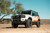 A modified white and orange 2024 LC250 Land Cruiser, viewed from the front left side to show off its aftermarket accessories and gear. A modified white and orange 2024 LC250 Land Cruiser, viewed from the front left side to show off its aftermarket accessories and gear.