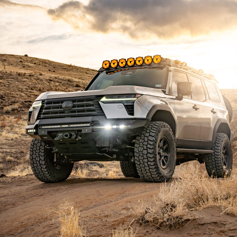 A grey Lexus GX550 (Lc250) in the dessert with a sunny sky, featuring an aftermarket steel front bumper. A grey Lexus GX550 (Lc250) in the dessert with a sunny sky, featuring an aftermarket steel front bumper.