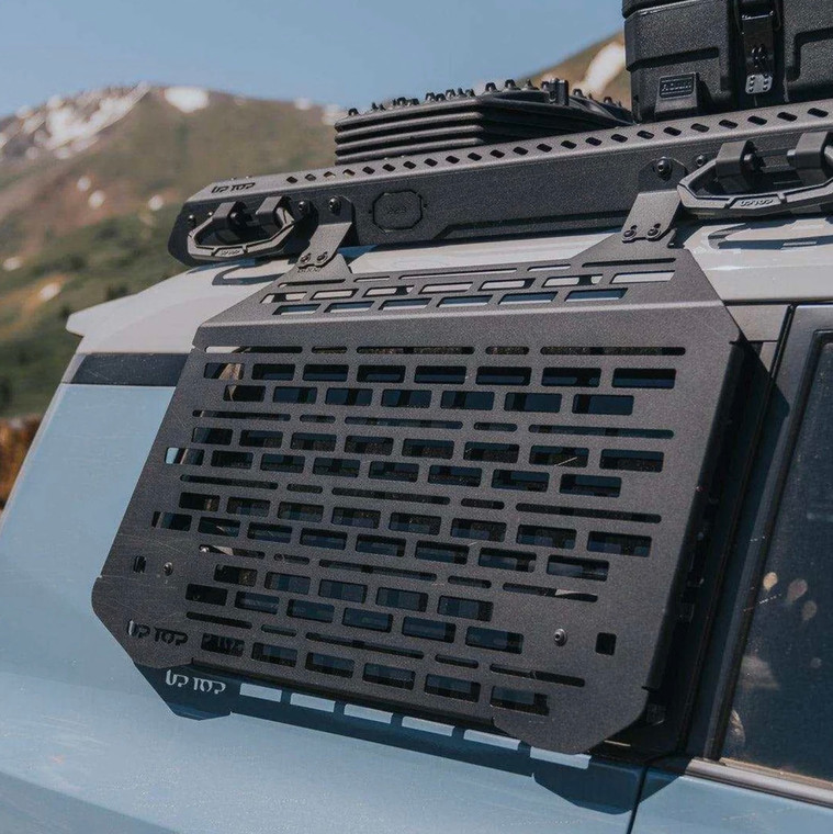 A close-up view of an upTOP Overland Window MOLLE/storage panel mounted on a blue LC250 Land Cruiser.